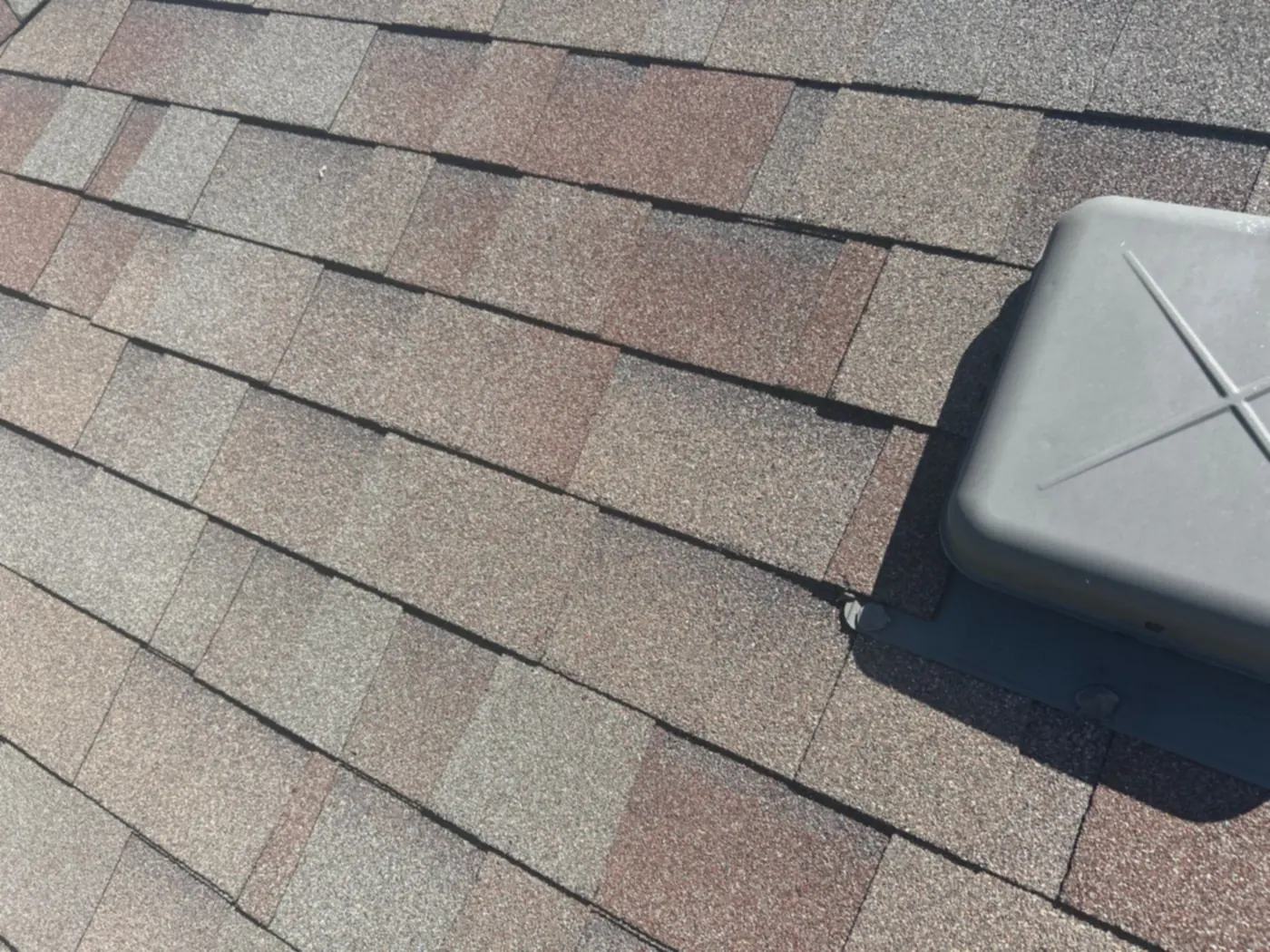 New asphalt shingles installed around a roof vent on a Shreveport home