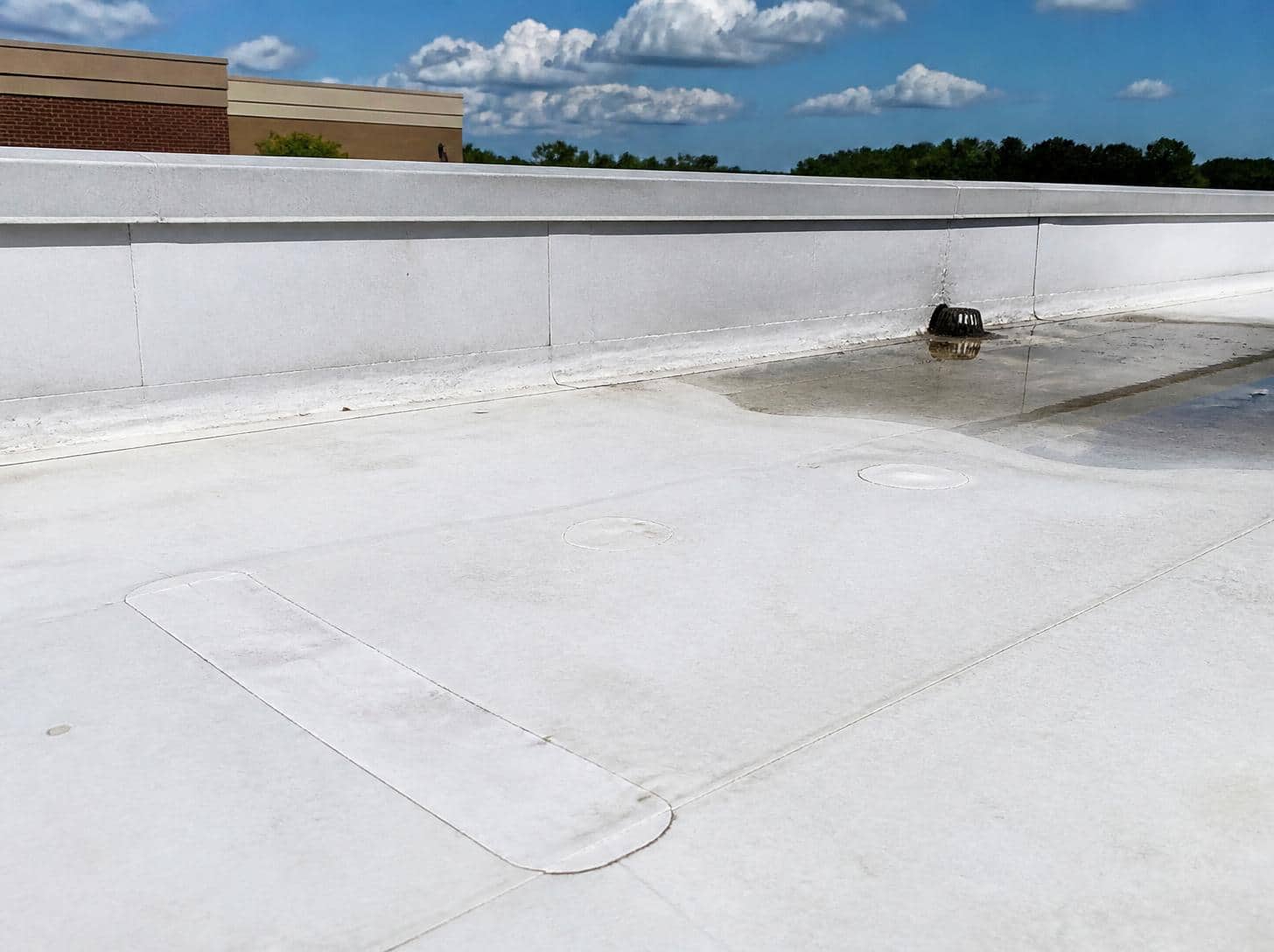 Commercial flat TPO roof with a seam repair patch and water ponding near the drain, a flat roof leak repair in Shreveport