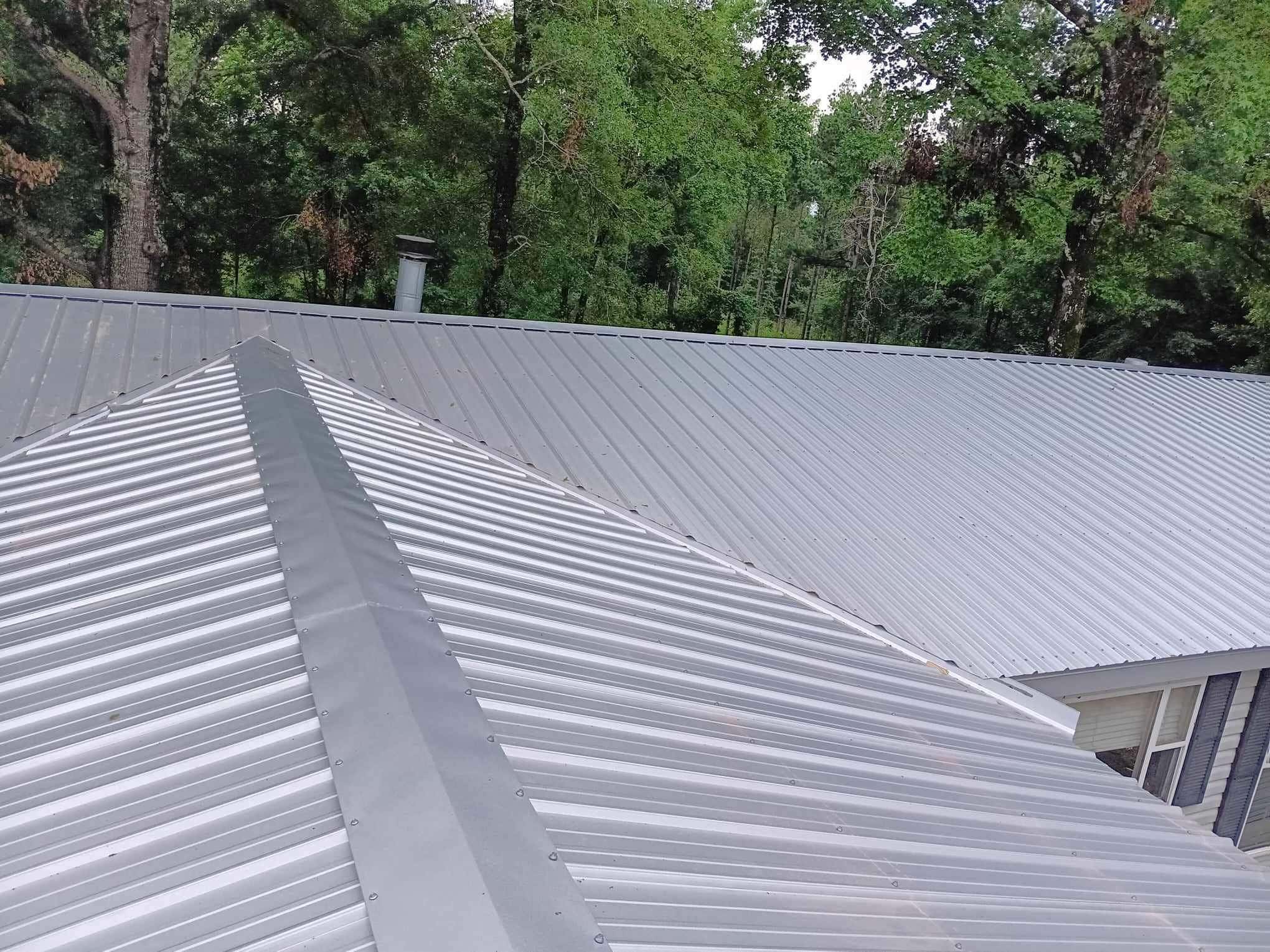 Screw-down metal roof panels and ridge on a commercial building repaired by Blue Note Pros in Shreveport