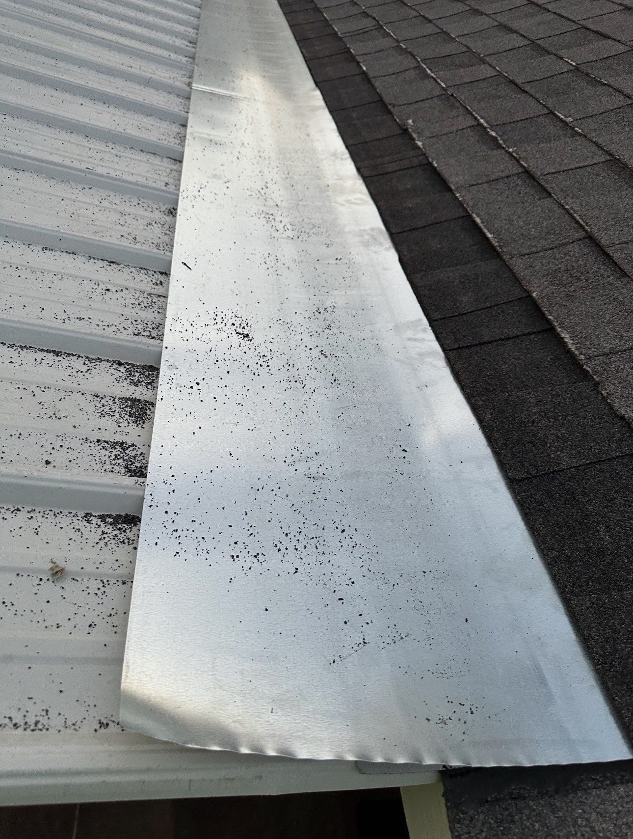 New metal transition flashing installed where a metal roof meets asphalt shingles during a roof repair in Shreveport