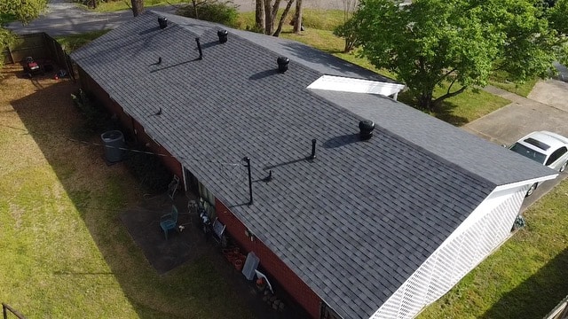 Drone view of a long shingle roof whose flat planes are measured in roofing squares to estimate reroofing cost