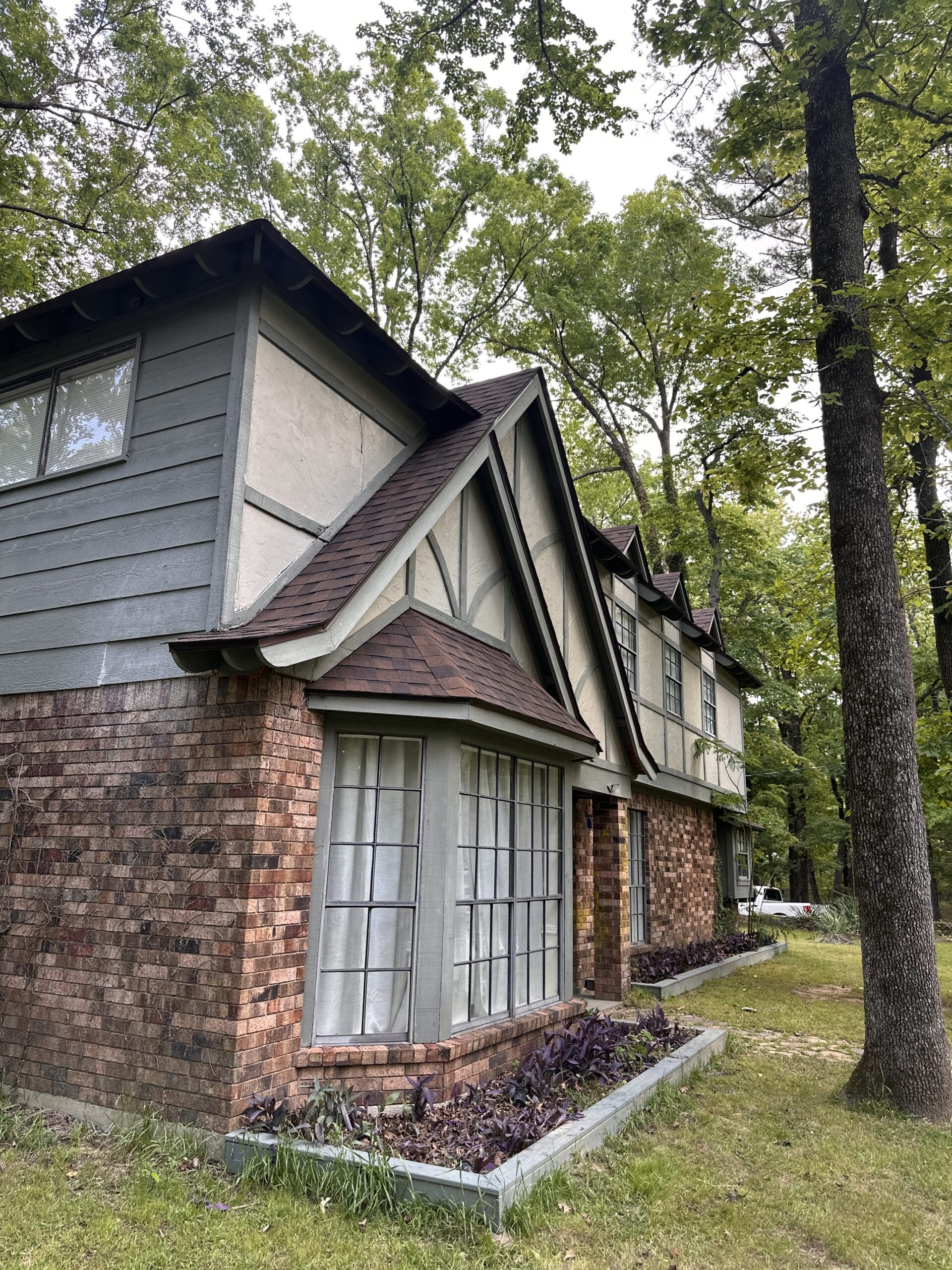 Two-story brick home with steep-pitched gables and a new architectural shingle roof in Shreveport