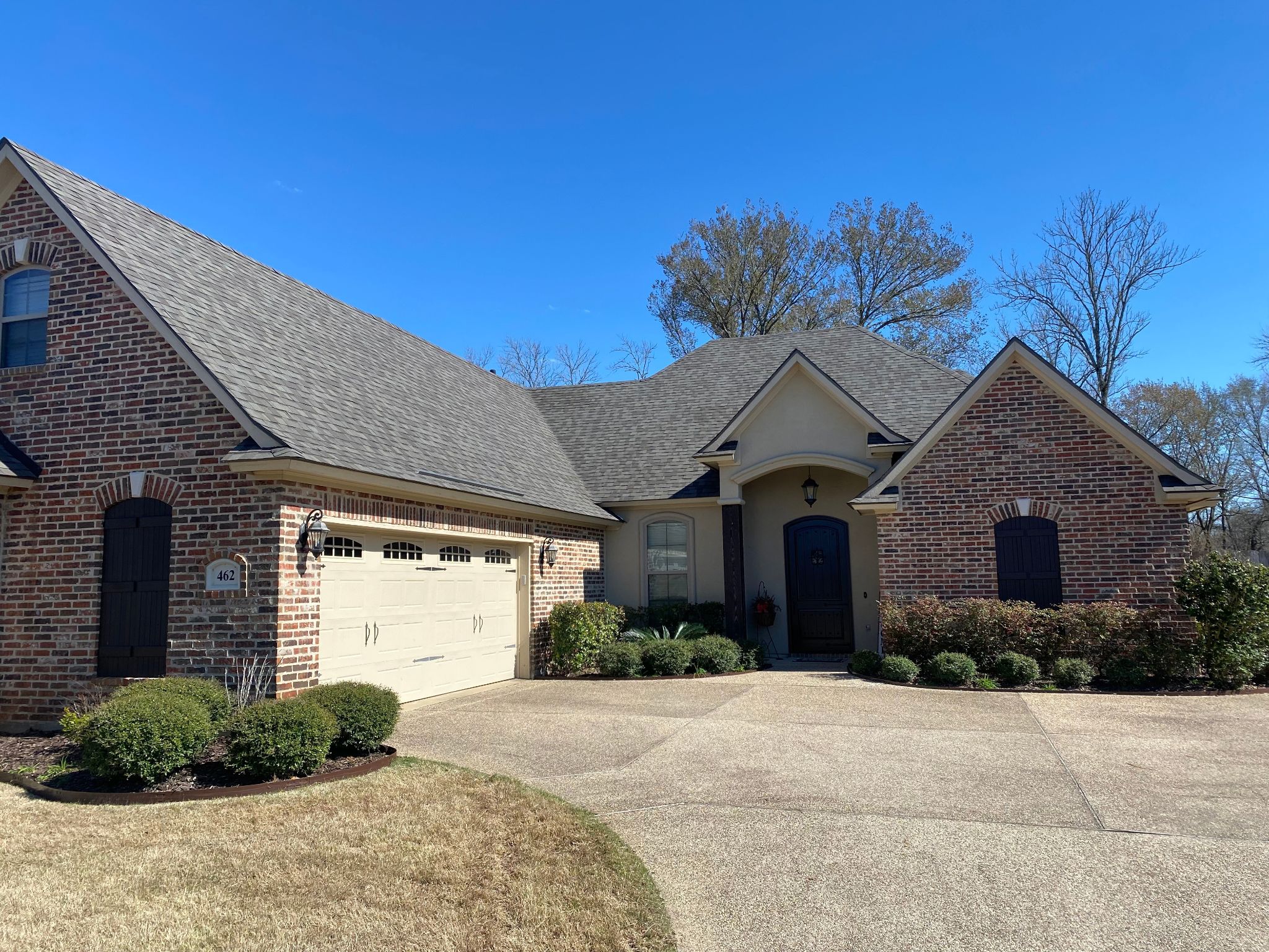 Completed asphalt shingle roof replacement on a brick home.