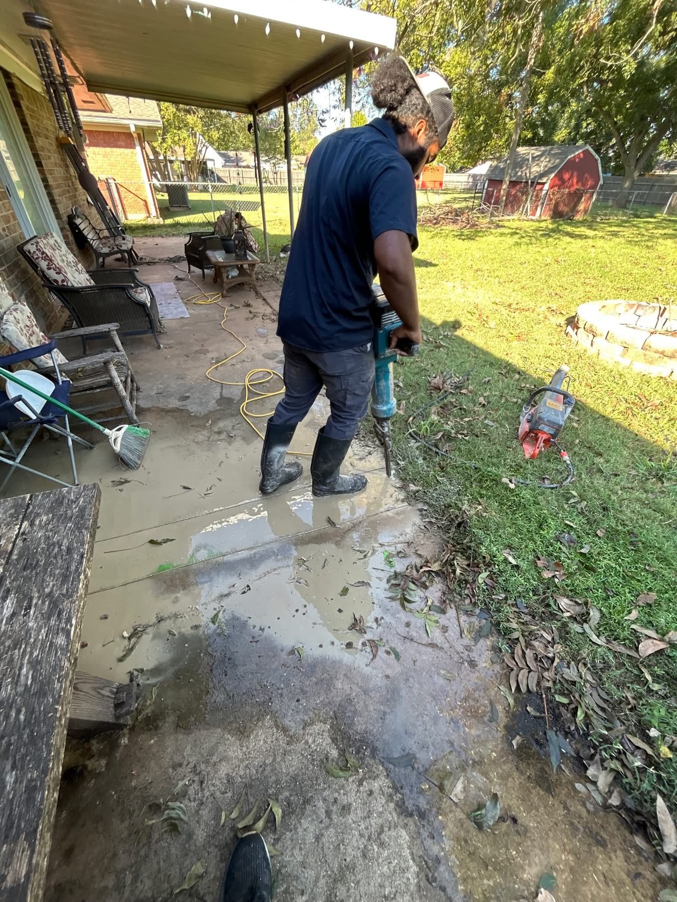Blue Note Pros plumber working on a flooded backyard patio during an emergency sewer repair